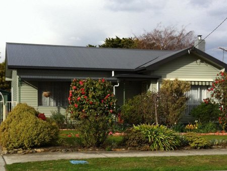 A small home with lots of plants around it