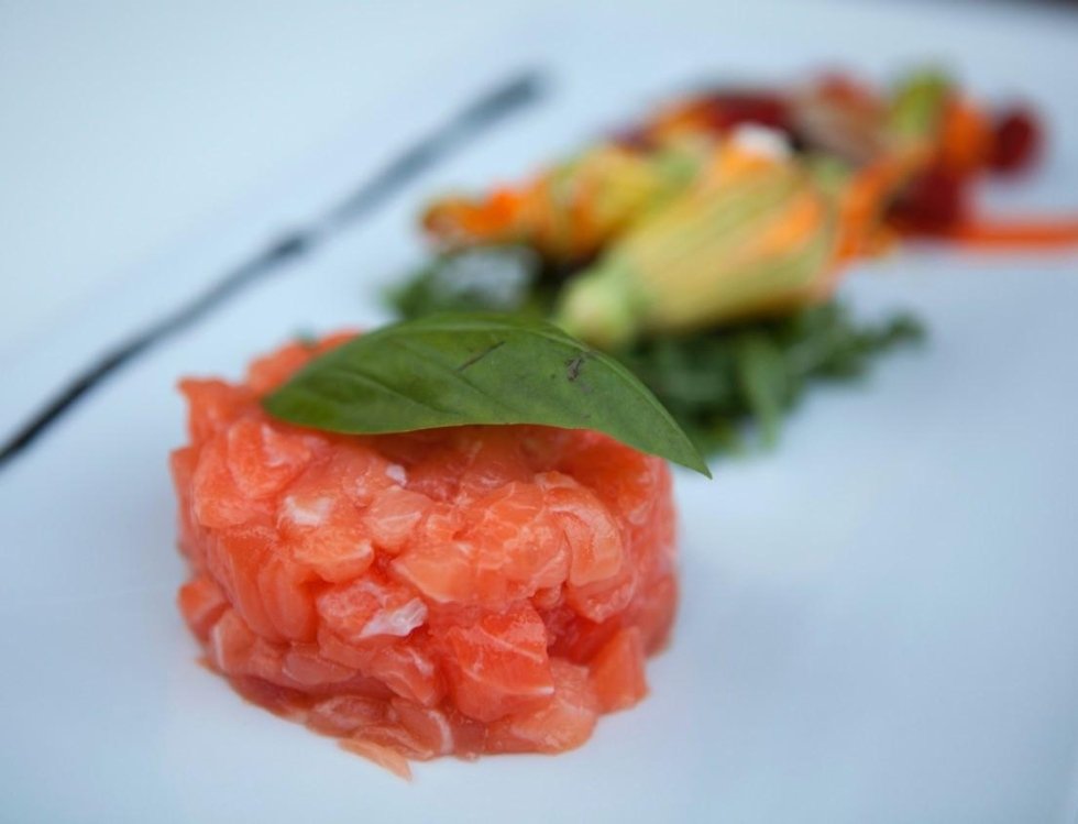 vista laterale di un piatto tartare di tonno, gamberi e fiori di zucca ripieni