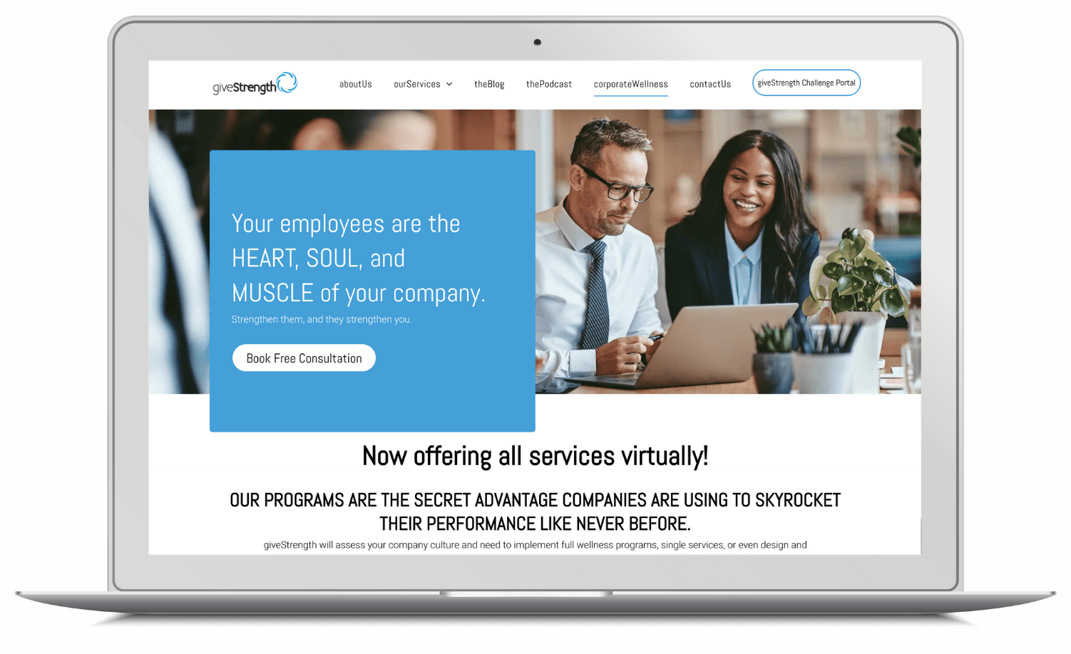 A man and a woman are sitting at a table looking at a laptop.