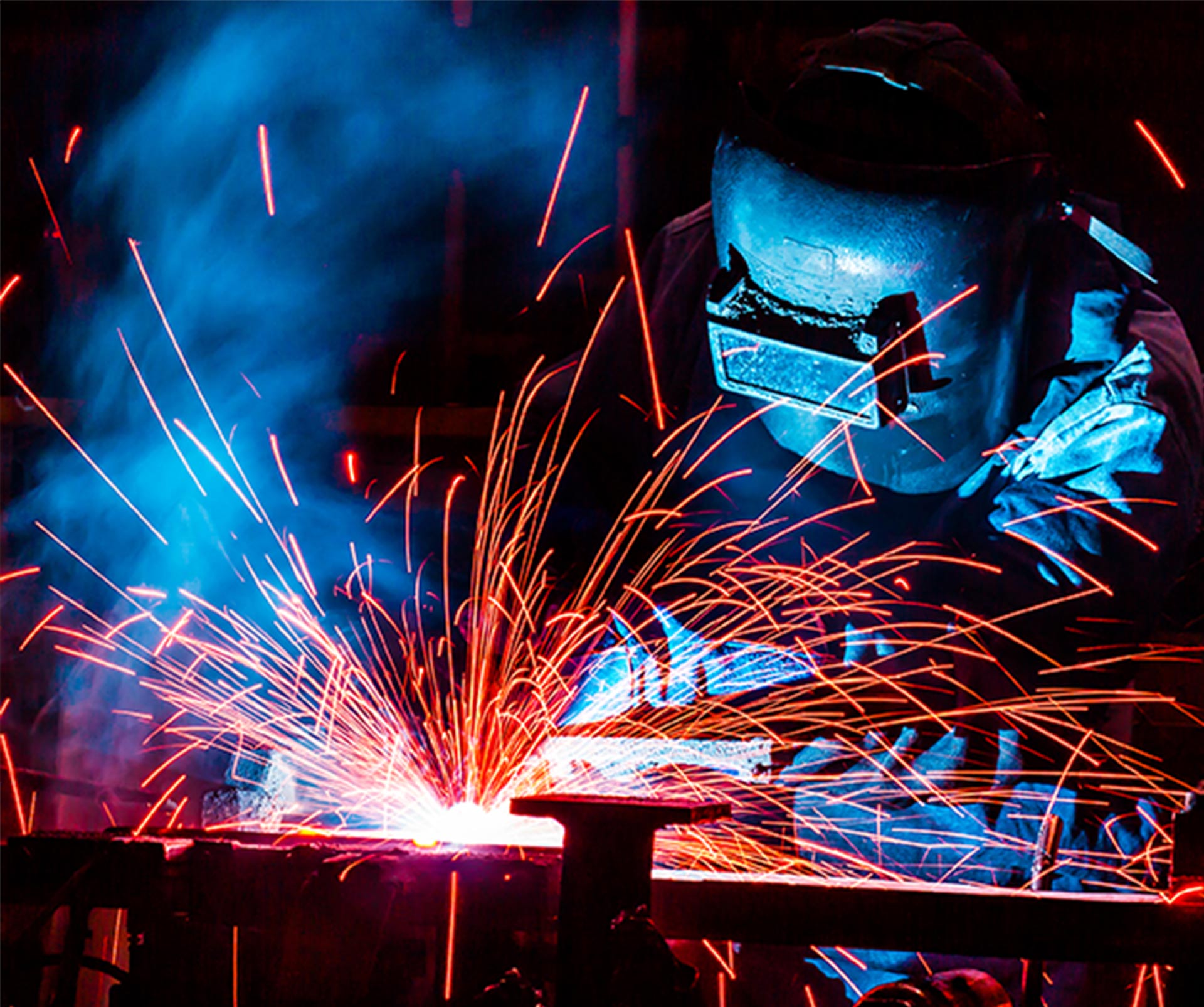 worker with protective mask welding metal