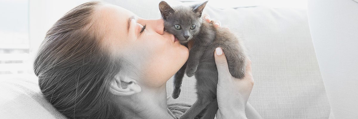 woman kissing kitten
