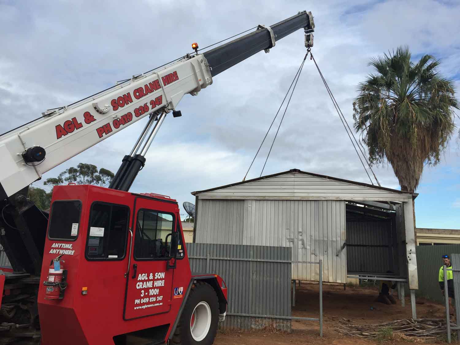 crane picking up shed