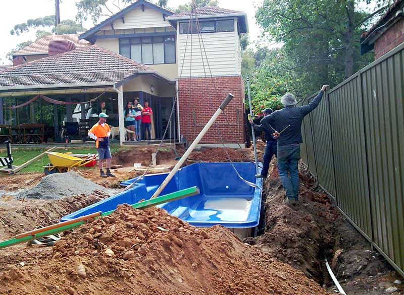 crane lowering pool in backyard