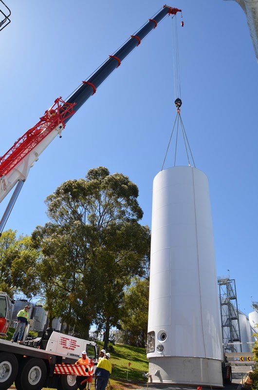 ground view of crane and white cylinder