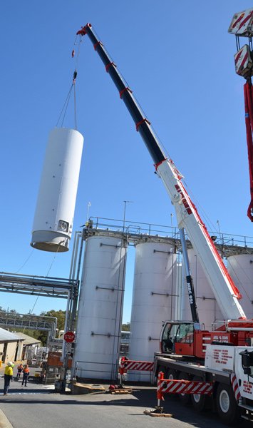 crane lifting white cylinder 
