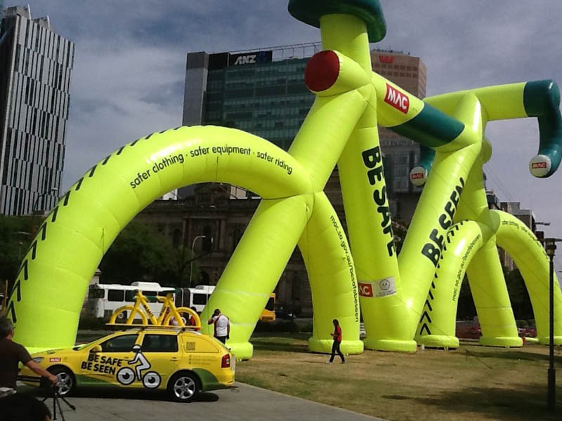 giant yellow bike next to car