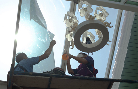 Two professionals installing roof window in a residential building