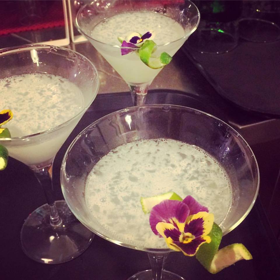 Cocktail con scorza di lime e viola del pensiero