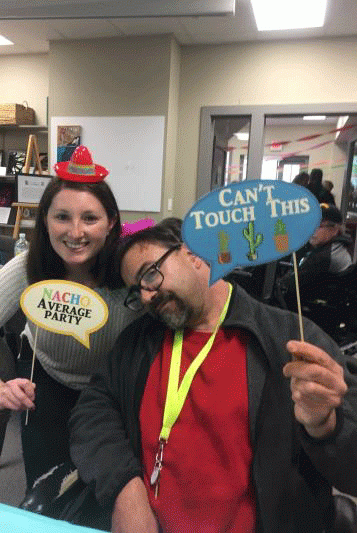 A man and a woman are posing for a picture with a can 't touch this sign.