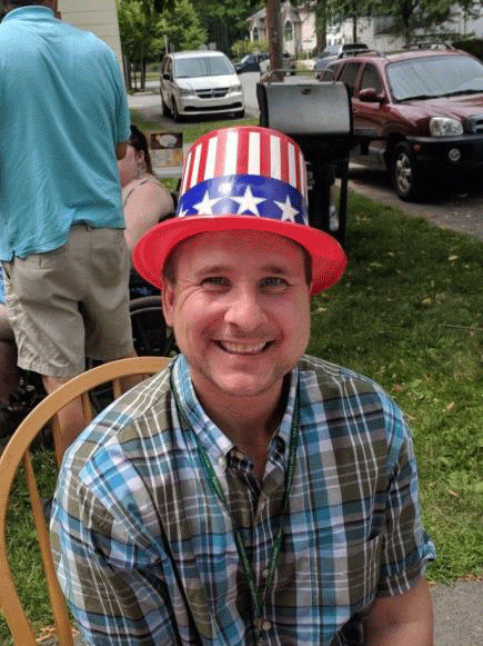 A man wearing an uncle sam hat is sitting in a chair
