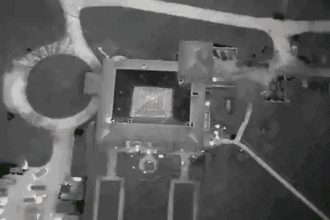 An aerial view of a large building in the middle of a field at night.