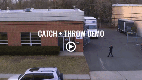 A man is walking in front of a building that says catch and throw demo