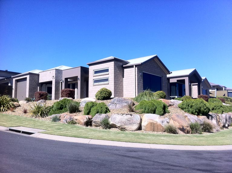 metal roofed home with lanscaped yard