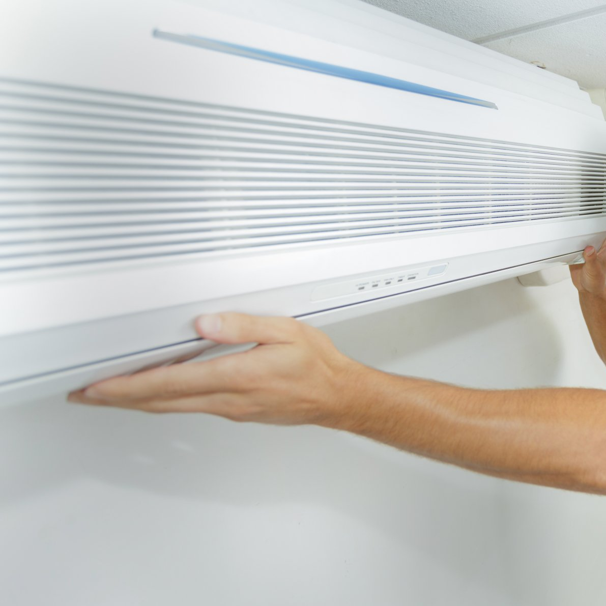 man servicing heat pump