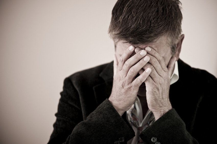 a man covering his face