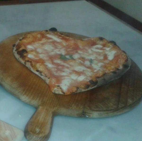 una pizza a forma di cuore su un tagliere