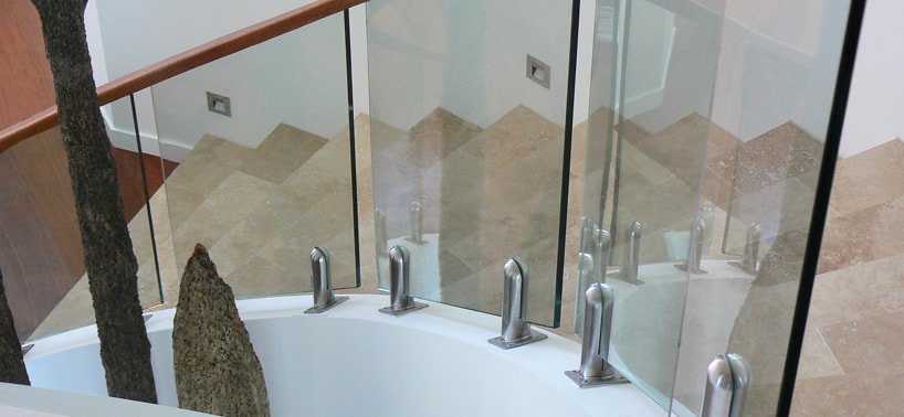 Staircase with top mounted curved timber handrail