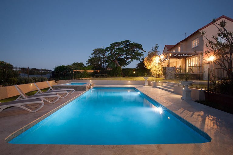 new pool and two storey house at dusk holland park