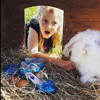 Young girl playing with a pet farm animal