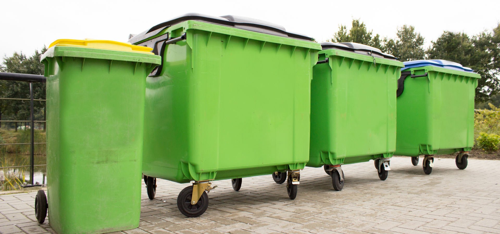 lightning bin hire four green garbage containers standing diagonally in a row
