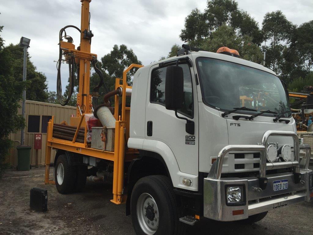 baines drilling white truck over the green grass