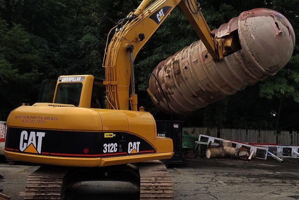 Excavator holding underground oil tank