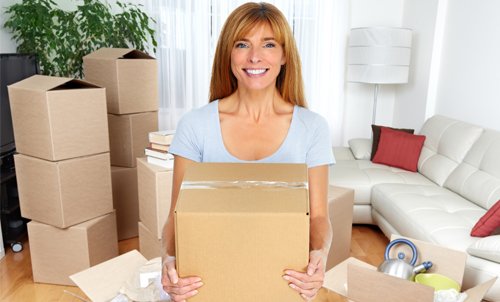 Woman with packed cartons ready for relocation