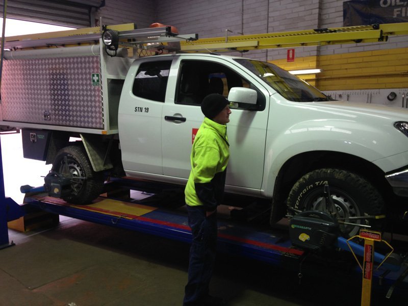 man in yellow vest standing next to vehicle