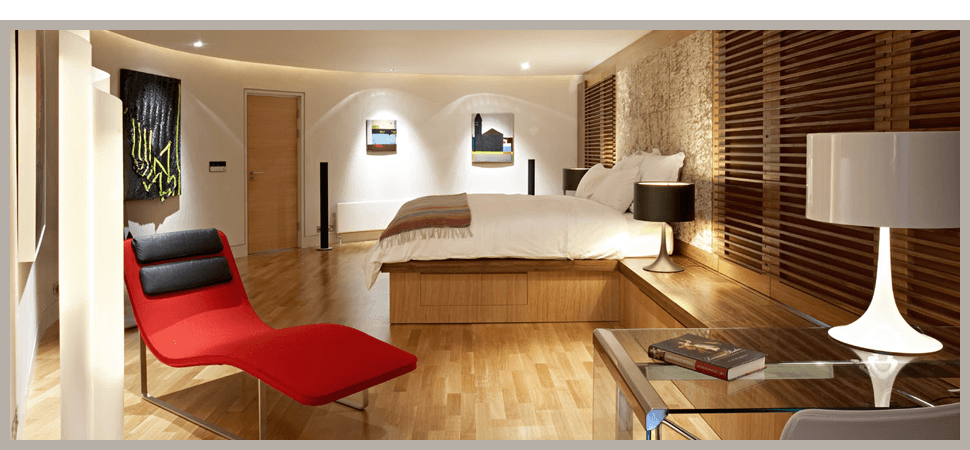 Bedroom with red chair, wooden flooring and wooden blinds