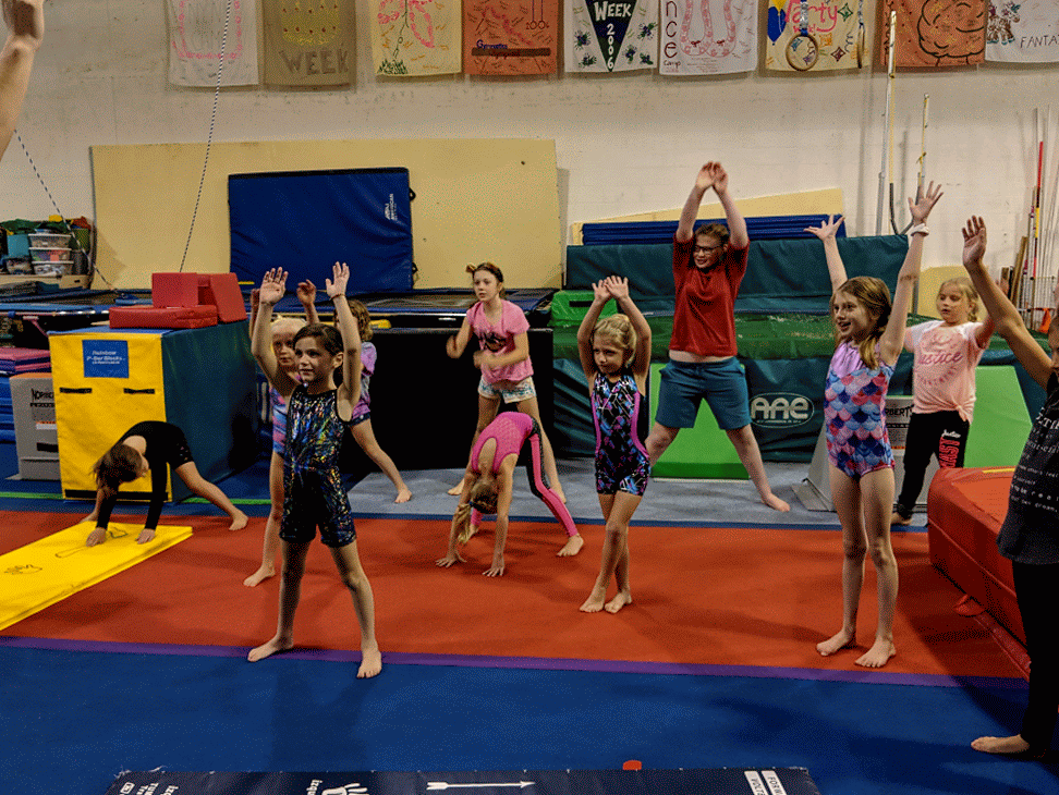A group of young girls are doing gymnastics in a gym.