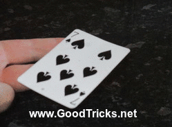 A playing card is seen to spin effortlessly on your finger tip.